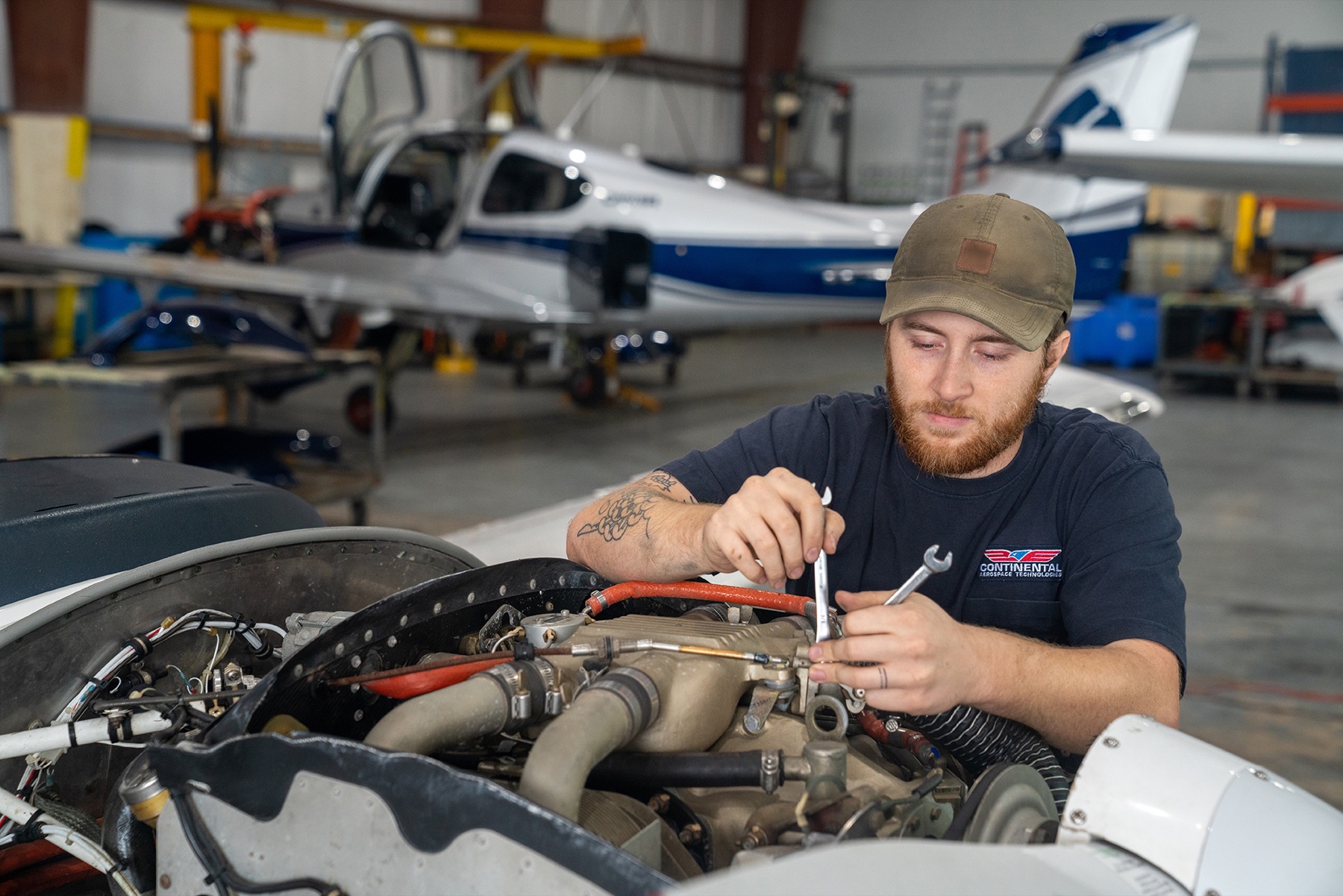 Continental Services technician working on a piston engine in the Fairhope hangar