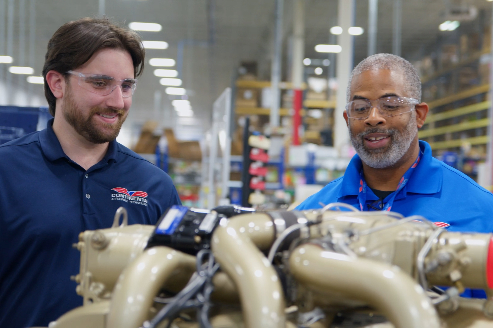 Two Continental technicians looking over an engine on the factory floor in Mobile